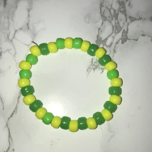 Hemmagjort armband  - Armband med gula och gröna pärlor som passar till allt. Den är i jättebra skick,har ni några frågar är det bara att skicka 