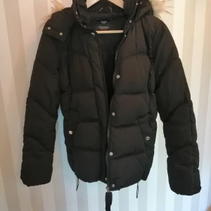 Dunjacka - En snygg, skön dunjacka från bershka med pälskant på luva och dragsko i nederkant. 