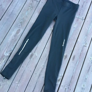 Soc träningstights storlek 34 - Praktiska träningstights med reflexer och liten ficka perfekt för telefon eller nycklar.