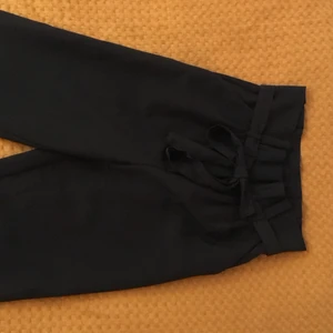 Svarta byxor, hög midja, knytband - Nyskick, använda en gång. Köparen står för frakt. Har annars möjlighet att mötas upp i Malmö.
