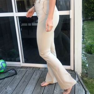 Kostymbyxor flare - Beige kostymbyxor med flare/bootcut. Använda 3 gånger, säljer pga för små för mig. Frakten är inkluderat i priset.