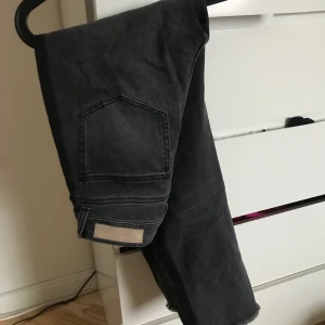 Grå jeans från Hunkydory - Otroligt snygga jeans från Hunkydory. Dom är grå, stretchiga och har en svart rand på sidorna. Har använt dessa max 5 gånger då de är för stora för mig! Nypris 1500 kr