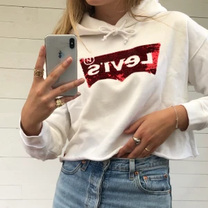 Levi’s croppad hoodie - Croppad hoodie från Levi’s med paljetter. ÄLSKAR materialet och luvan är stor och rymlig. Använd få gånger och i väldigt fint skick. Hör av er vid intresse! ❤️