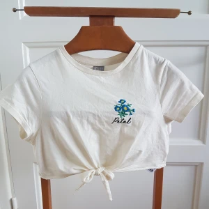 Croppad vit t-shirt  - Jättesöt vanilj-vit t-shirt med knytning i fram. Köpt här på plick men är tyvärr för kort för mig. :( Det är en small men skulle säga att den passar bättre på en xtra small! Frakt ingår. :)