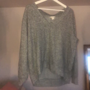 Grå tröja  - Grå tröja, veringad och lite längre där bak.