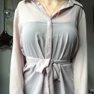 Ljusrosa blus med knytning i midjan  - Superfin genomskinlig blus med knytning i midjan, skärpet är avtagbart. I nyskick, säljer då det inte kommer till användning. Strl S😊