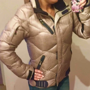  - Säljer nu min Peak jacka, guldmetallick i färgen, tunn täckjacka, men ändå väldigt varm Fint skick! Storlek M eller en stor Small Nypris 2199kr 