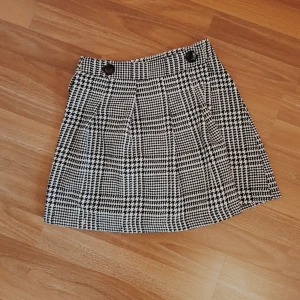  - Fin grafisk skolflickskjol i svartvitt mönster, stänges omlott med två knappar. Minns inte vart den är ifrån men kan ha varit OASAP eller liknande, tiptopskick då den endast är använd en gång runt jul. Är en 36a och skulle vilja säga att man bör vara en S/34 för att den ska sitta bekvämt, en smula för liten för mig. 