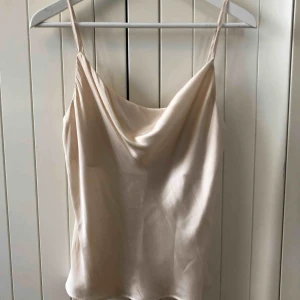  - Aldrig använt! Champagne färgat linne med reglerbara axelband.   Material 100% Polyester   Upphämtas i centrala Uppsala Porto tillkommer vid frakt, 18kr