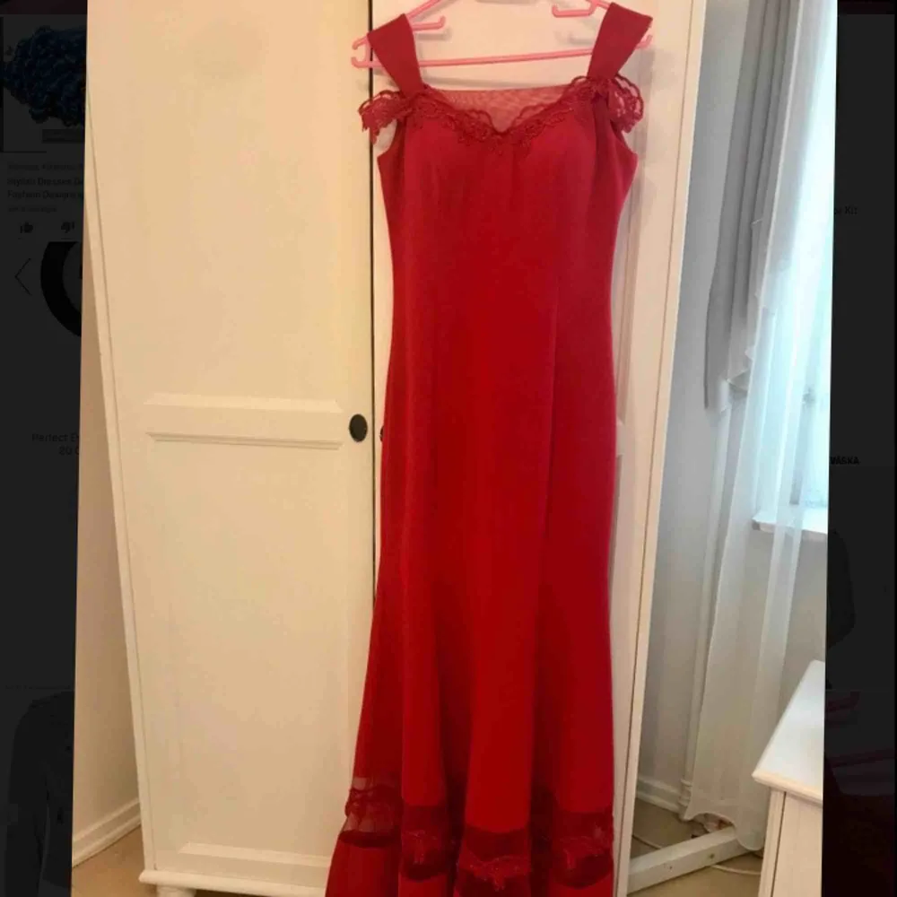 Röd lång klänning med fina blomdetaljer med en extra sydd transparent tyg på baksidan. XS i storlek och använd bara 1 gång på bröllop. Frakt eller mötas upp kan diskuteras.. Klänningar.