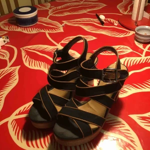  - Ett par svarta klackskor med bruna detaljer och silver spännen, otippat bekväma