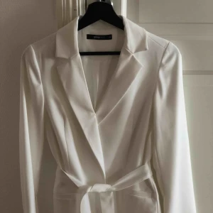  - Vit kavaj med avtagbart band i midjan 