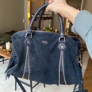 Zadig & Volatire, väska - Säljes min fina Zadig väska inköpt i USA. Går både att ha som handväska och axelremsväska. Bandet går att justera. Man kan göra den större eller mindre då den har dragkedjor som ni ser på bilderna. Mörkblått Mocka- material. 😍😍