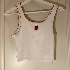 vitt linne - kort linne med broderad jordgubbe, lettuce-söm längst ner. köpt på new yorker så billig!!! storlek large men den sitter bra på en mindre person också, bara lite lösare 