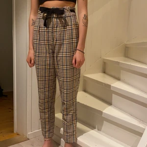 Rutiga kostymbyxor från Zara - Rutiga kostymbyxor med svart fastsytt ”snöre” (som går att dra åt) från Zara i gott skick 💘 storleken är S, dom är normala i passformen (hon har S i vanligtvis också).  Köparen står för frakten men jag kan även mötas upp i närheten. 🥳