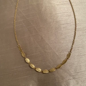 Guldigt Halsband med löv - Ett fint oanvänt halsband med söta blad! Kommer tyvärr inte till användning... 💛