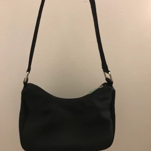 Liten svart väska - Söt liten väska, trots den är liten är den väldigt rymlig & har en extra ficka inuti om man vill separera innehåll från varandra :) 