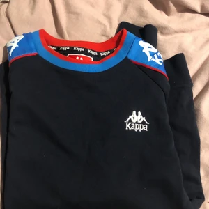 Kappa tröja - Svart kappa tröja med blått på armen. Knappt använd alls, storlek S