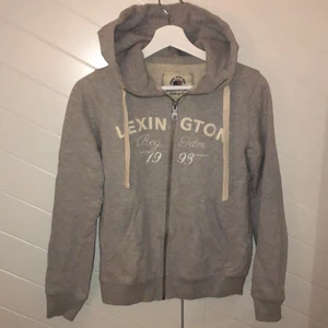 Kofta från Lexington - Ljusgrå kofta med luva från Lexington (är äkta) med vita detaljer, är i normalt skick. Köparen står för frakt💕
