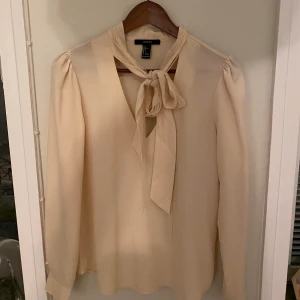 Ljusrosa blus  - Ljusrosa blus med band som man kan knyta framtill. Aldrig använd, storlek Small. Säljer för 75kr