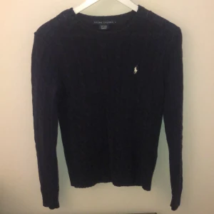Mörk blå Ralph Laurens kabelstickad tröja  - En mörkblå, kabelstickad Ralph Laurens tröja som sitter jättefint på. En skjorta under piffar upp den ännu mer! Är M men sitter som en S.