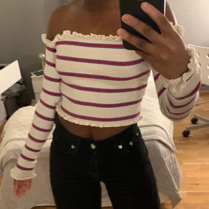  Off-shoulder tröja  - En off-shoulder tröja med blå, rött o vit randigt mönster.