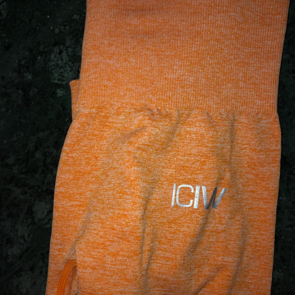 Säljer ett par orangea träningstights från ICIW. Storlek XS. . Jeans & Byxor.