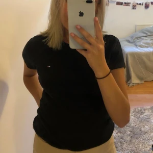 Tommy Hilfiger T-shirt - svart Tommy Hilfiger t-shirt. den är äkta och i mycket fint skick! den är stretchig och passar även folk med S utan att den ser för stor ut🖤
