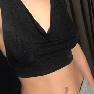 svart glittrig topp/linne - svart glittrigt tyg, en rektangel som du knyter i nacken+ryggen. endast testad, säljer pga såg annorlunda ut på hemsidan, fortfarande fin men inte vad jag hade väntat mig. köparen står för frakt.