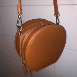  - Brun väska med guldiga detaljer, går att byta band!  (Bandet är litelite skadat) Kan mötas upp i Lund, annars står köpare för frakt!