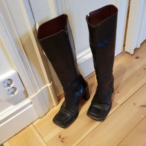 Skinnstövlar 70-talsstil - Stövlarna är i retrostil. De är sköna att gå i eftersom de har bred klack. Stövlarna kan hämtas på Södermalm eller på annan plats i Stockholm. Annars betalar du frakten