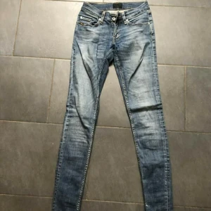 Tiger Jeans - Supersnygga Tiger Jeans stl 27/34. Låga i midjan. Finns en liten slitning längst ner på byxan annars i fint skick!