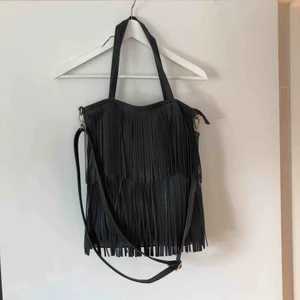  - Väska med fransar från Gina Tricot. Ett stort fack och 3 små fack i väskan. Silverdetaljer. 