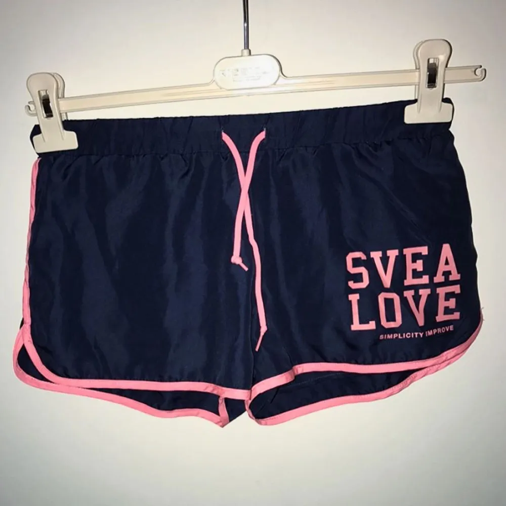 Marinblå & rosa shorts från Svea i storlek 140/150 vilket motsvarar XS!  Endast använd en gång!  Shortsen kan användas i träningssyfte likväl som att ha till vardags! . Shorts.