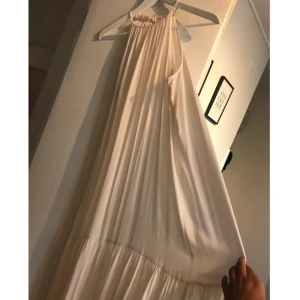  - Klänning som aldrig är använd. Benvit. Passar alla kroppsmodeller. Lite uppsydd. 