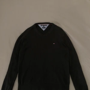 Tommy Hilfiger  - En svart v-ringad tröja, lite urtvättad. Godtar även bud