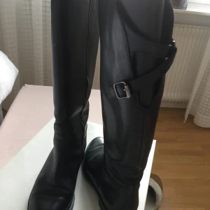 Svarta stövlar - Typ ridstövlar med fina detaljer. Obetydlig använda. 