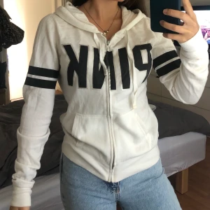 PINK hoodie - Säljer mysig vit/svart hoodie från PINK då den inte kommer till användning längre. Storlek XS