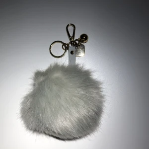 Väskaccessoar  - Fluffig grå boll att ha på väskan. Använt någon enstaka gång. Frakt tillkommer.