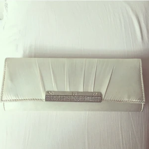  - Elegant liten afronväska/clutch. Passar till olika festsammanhang. Ca 30 cm lång och 10 cm bred.