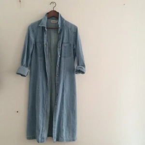  - Jeanskappa eller klänning, härlig modell som blir vad man använder den som. Ljus denim. Vita sömmar. Frakt tillkommer eller hämta i centrala Gbg.