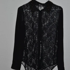  - Snygg skjorta med detaljer på kragen. Svart Transparant. Sparsamt använd.