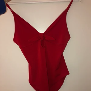 Röd body - Röd body med V-ringning och knytning, i storlek S. Använd endast ett fåtal gånger, nytt skick. Kan hämtas på Alnö men kan även skickas, köparen står för frakt. Rök och djurfritt hem👍🏻