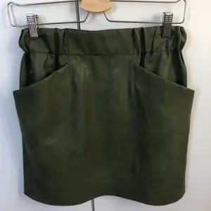 Kort militärgrön kjol i skinnimitation från Zara. Passar perfekt nu till hösten till ett par kängor. Aldrig använd endast testad så som ny. 