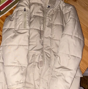 Jacka  - En vinterjacka i ljust beige färg, använd fåtal gånger, den är hel. 