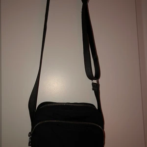 Liten väska  - Liten men rymlig väska! Fint skick! Inte använd så mycket. Köpt på weekday. Justerbart band.