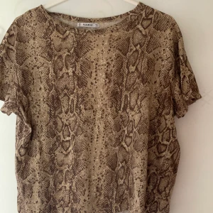 Pull & bear T-shirt  - T-shirt med reptil-print från Pull & bear. Strl xs men passar mig med S/M också 