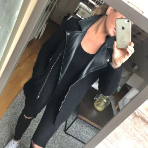 Kortare kappa - Kortare figursydd svart kappa med krage i konstläder med tultad ull/polyester lite rockigare stilen men samt väldigt dressad, knappt använd.