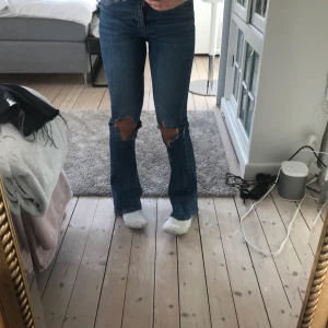 Bootcut jeans med hål - Snygga blå bootcut jeans med egen klippta hål! Säljer pga att de är för tajta på mig, i min smak! 