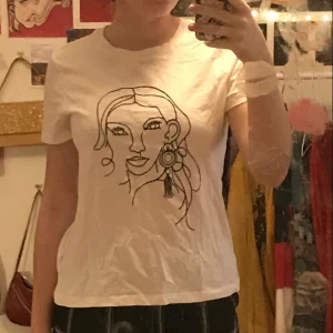 t-shirt med tryck - vit t-shirt med tryck av ansikte. köpt från cubus. i gott skick